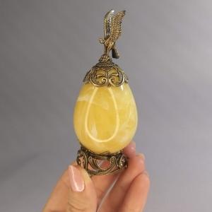 Яйцо из янтаря в бронзе с коршуном на подставке - высота 11 см