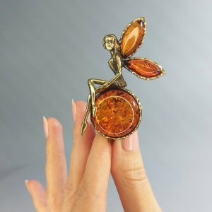 Брошь из янтаря в бронзе - Фея на шаре 35х70 мм